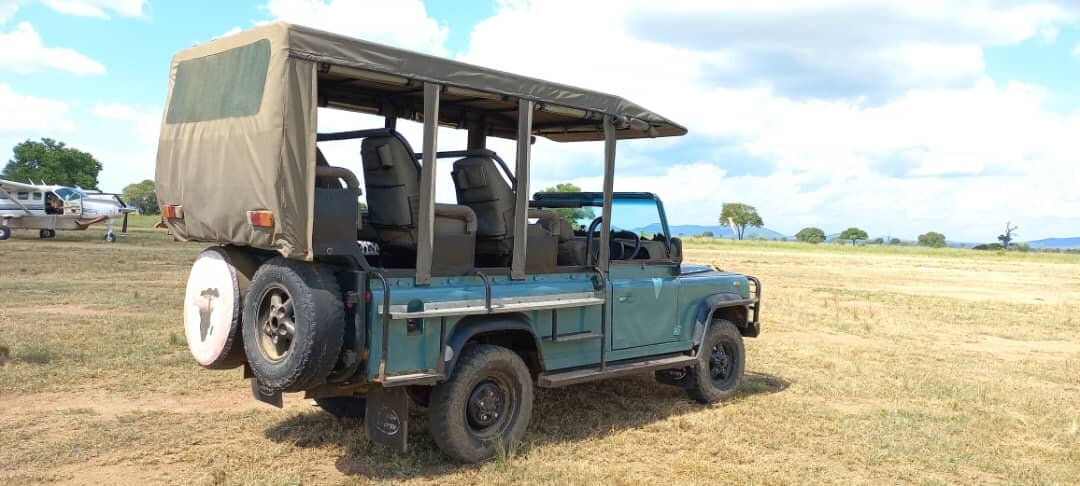Open-sided game drive vehicle parked on the airstrip in Mikumi National Park