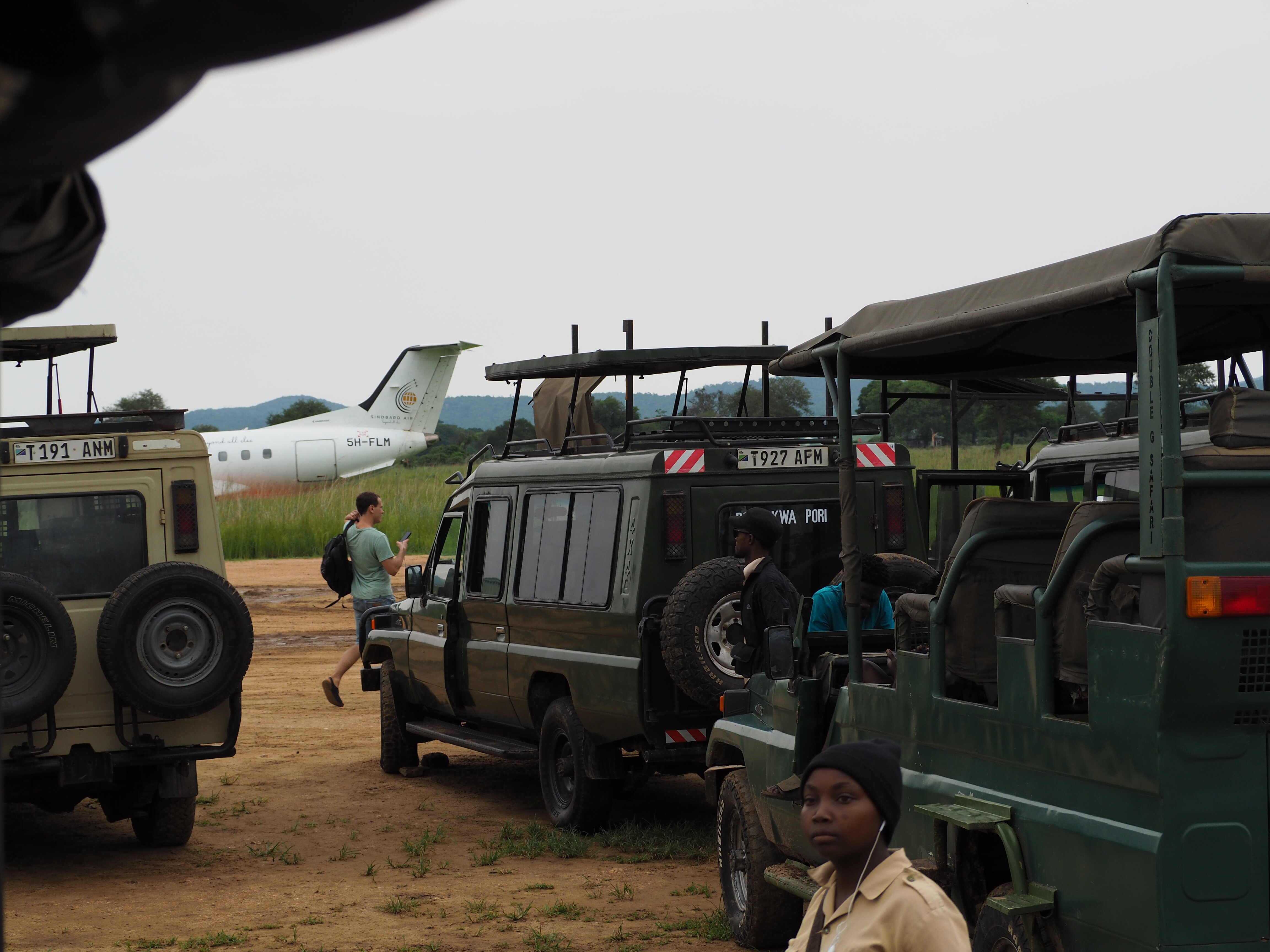 Safari vehicles and light aircraft at the Mikumi airstrip